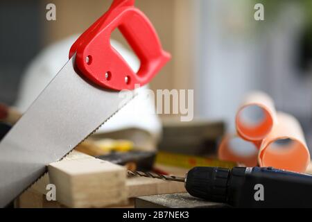 Hand saw mounted on wooden bar, near drill hammer Stock Photo