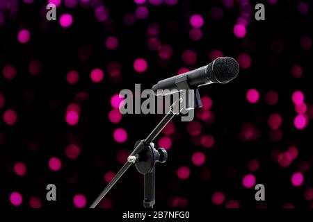 Microphone close up shot on blurred bokeh Purple Pink background beautiful romantic or glitter lights circle soft on dark background, Night Party Sing Stock Photo
