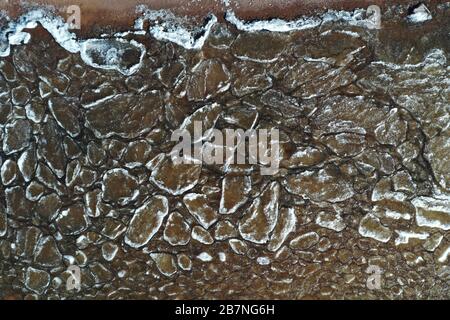 Pieces of ice float on waves, Ice plaques, sandy coast, stones, spring landscape, sunny weather, pacification Stock Photo