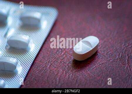 White single pill lies on the dark background Stock Photo