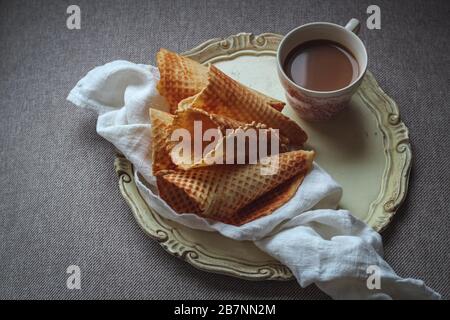 Home made thin waffles and a cup of coffee with milk on a tray for a weekend brunch Stock Photo