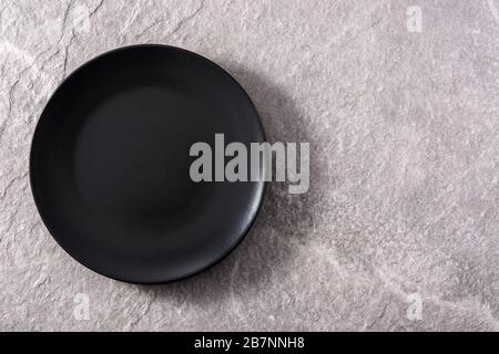 Empty black plate on gray background Stock Photo