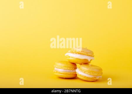 Three yellow lemon macaroon in stack on yellow background, close-up, place for text, copy space, horizontal Stock Photo