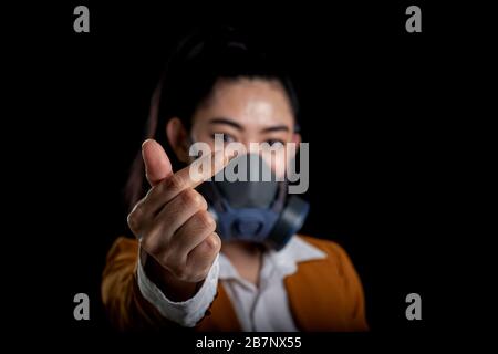 Businesswoman of young Asia woman putting on a respirator N95 mask to protect from airborne respiratory diseases as the flu covid-19 coronavirus PM2.5 Stock Photo