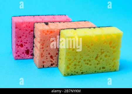 Sponges for washing and cleaning multicolored on blue background. Stock Photo