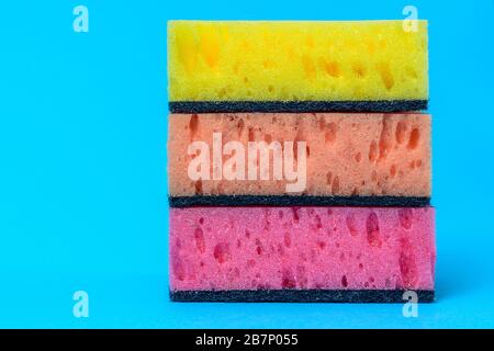 Sponges for washing and cleaning multicolored on blue background. Stock Photo