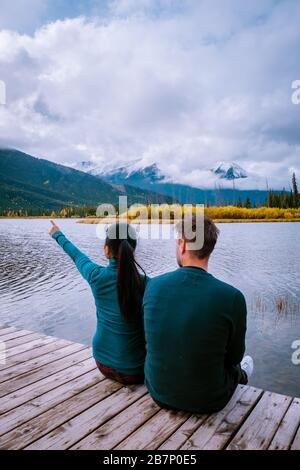 couple by the lake watching sunset, Pyramid lake Jasper during autumn in Alberta Canada, fall colors by the lake during sunset, Pyramid Island Jasper Stock Photo