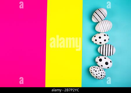Different graphic hand drawn eggs on bright background in trendy colors. Easter concept. Place for text. Stock Photo