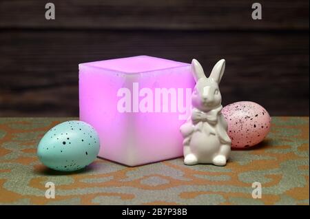 Ceramic Easter Bunny, Eggs and Glowing Square  Pink Wax Candle Stock Photo