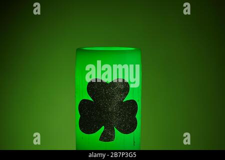 Glowing green wax candle for St. Patrick's Day Celebration Stock Photo
