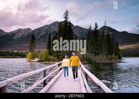 couple by the lake watching sunset, Pyramid lake Jasper during autumn in Alberta Canada, fall colors by the lake during sunset, Pyramid Island Jasper Stock Photo