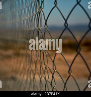 defocused detail of a piece of fence or flexible metal lattice on the outside Stock Photo