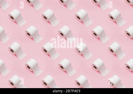 Rolls of white toilet paper on pink background. Creative minimalist pattern. Stock Photo