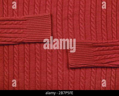 Close up background texture of red cable knitted wool jersey fabric sweater with row braid pattern Stock Photo
