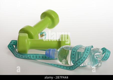 https://l450v.alamy.com/450v/2b7pak4/water-bottle-tied-with-cyan-blue-measure-tape-by-green-dumbbells-on-white-background-athletics-and-weightloss-concept-refreshment-and-diet-equipment-bottle-wrapped-with-tape-by-lightweight-barbells-2b7pak4.jpg