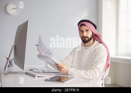 Arab businessman worker works in computer on the workplace in the office. Stock Photo