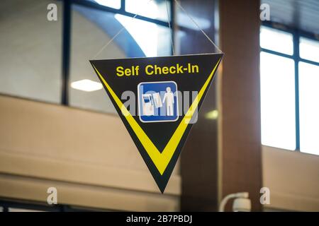 Self check-in sign inside an international airport Stock Photo