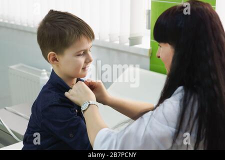 Mother buttoning son's shirt. A mothers love and care. Happy childhood Stock Photo