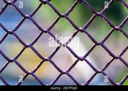 Metallic chain fence link net with blue defocused background Stock Photo