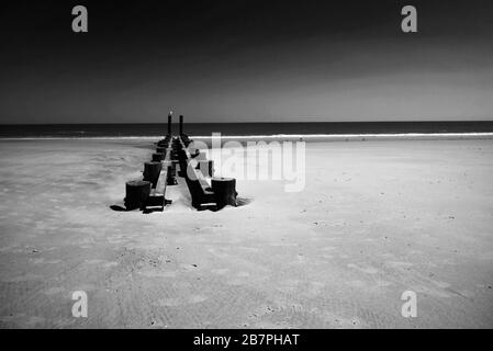 Wooden pier remains on Atlantic City Beach. Black-and-White Photography. Stock Photo