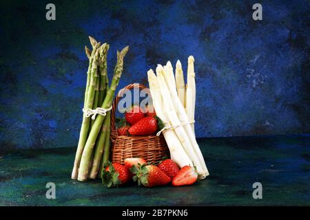 White and green fresh asparagus with a bunch of healthy strawberries Stock Photo