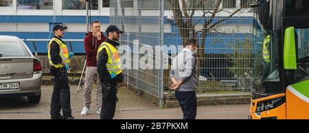 Kehl, Germany - Mar 16, 2020: Driver of intercity bus wearing white protection mask and police officers inspection checkpoint at border crossing Kehl Strasbourg crisis measures against coronavirus Stock Photo