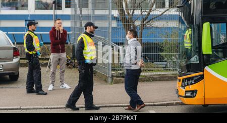 Kehl, Germany - Mar 16, 2020: Driver of intercity bus wearing white protection mask and police officers inspection checkpoint at border crossing Kehl Strasbourg crisis measures against coronavirus Stock Photo