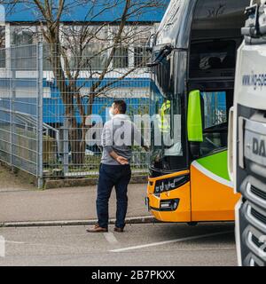 Kehl, Germany - Mar 16, 2020: Driver of intercity bus wearing white protection mask inspection checkpoint at border crossing Kehl Strasbourg crisis measures against coronavirus Stock Photo