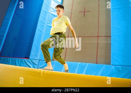 Teenage boy jumping on trampoline park in sport center  Stock Photo