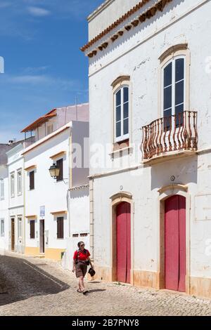 Woman walking down a street with red hair in flick ups Stock Photo - Alamy