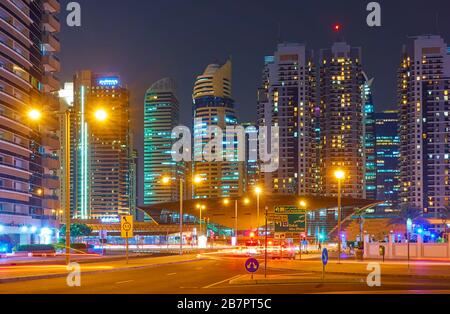 Dubai, UAE - January 30, 2020: DAMAC Metro Station and modern towers along Sheikh Zayed road in Dubai at night, United Arab Emirates