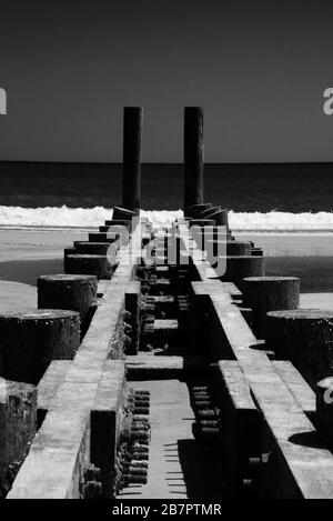 Wooden pier remains on Atlantic City Beach. Black-and-White Photography. Stock Photo