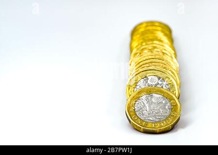 CARDIFF, WALES - JANUARY 2020: Close up view of British currency GBP - One Pound coins on a plain white background Stock Photo