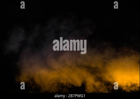 yellow smoke isolated on black background Stock Photo