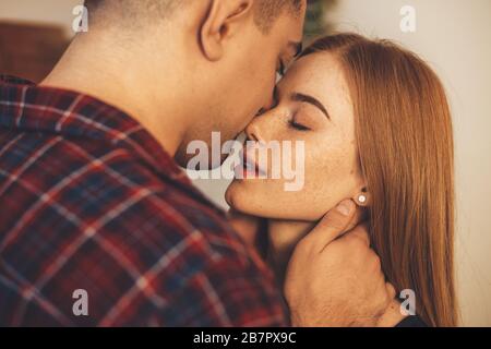 Lovely caucasian couple kissing each other during a warm morning together Stock Photo