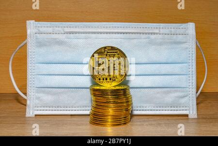 Gold coins with a medical mask. A business finance concept Stock Photo