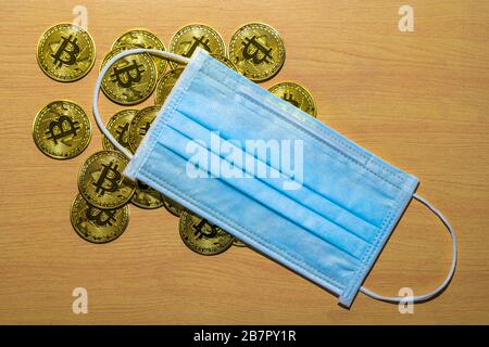 Gold Bitcoin coins with a medical mask. A business finance concept Stock Photo