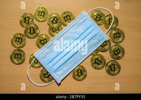 Gold Bitcoin coins with a medical mask. A business finance concept Stock Photo