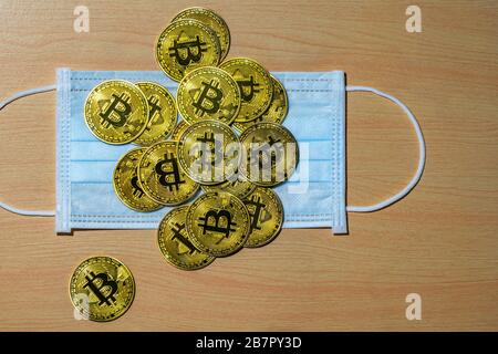 Gold Bitcoin coins with a medical mask. A business finance concept Stock Photo