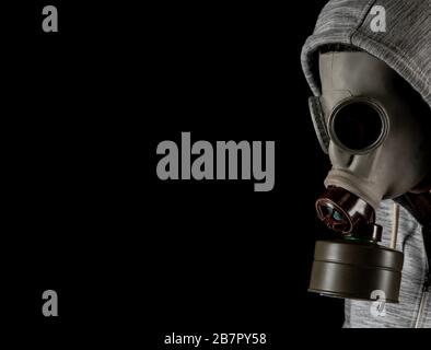 man in a gas mask on a black background. protection against viruses Stock Photo