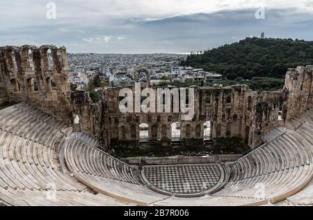 Athens, Attica / Greece - 12 26 2019: View over the steps and marble seats of the Dyonisus theater and natural rock landscape surroundings Stock Photo