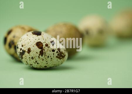 Quail eggs close-up on a green background.Easter holiday symbol.Easter card,copy space.Macro photo. Stock Photo