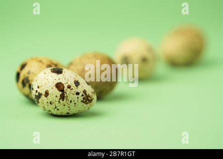 Quail eggs close-up on a green background.Easter holiday symbol.Easter card,copy space.Macro photo. Stock Photo