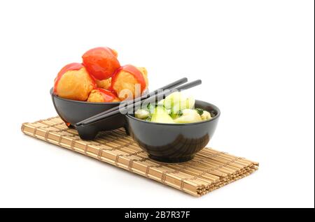Chinese food, stir fried bok choy with garlic and sweet and sour chicken on a white background with copy space. Stock Photo