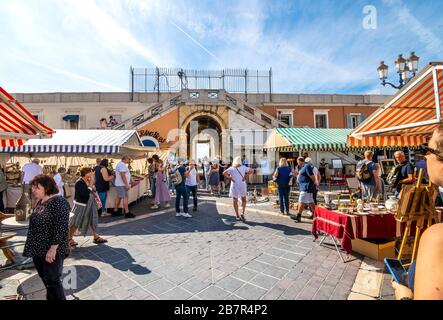 Tourists enjoy a sunny summer morning at the Cours Saleya outdoor market in the Old Town district of Vieux Nice, France, on the French Riviera. Stock Photo