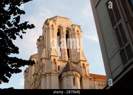 One of the bell towers highlighted from behind as the sun sets at Notre Dame Cathedral in Nice, France, on the French Riviera. Stock Photo