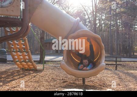 Newport News, VA/USA-March 1,2020: A young girl coming down a slide head first on the playground at Newport News Park. Stock Photo