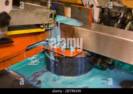 An automatic saw cuts stainless steel square tubing that will be used in equipment that extracts the oil from hemp. Stock Photo