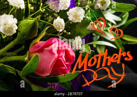 Holiday card - beautiful gift bouquet of various colorful decorative summer flowers, holiday greetings, handwritten inscription with a brush Mothers Stock Photo