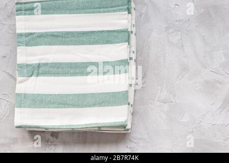 Striped green and white kitchen towels on gray background, top view, copy space Stock Photo